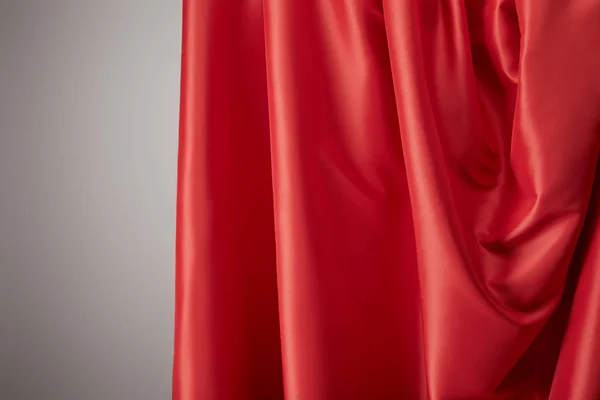 Крупним планом вид на червону м'яку і хвилясту шовкову текстуру тканину на сірому фоні — стокове фото
