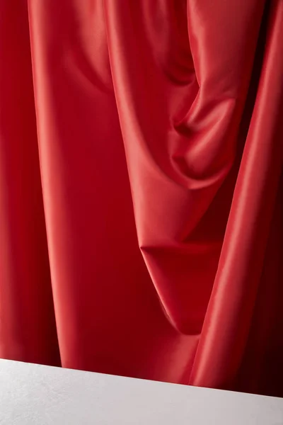 Close up view of red soft and wavy silk textured cloth and white surface — Stock Photo