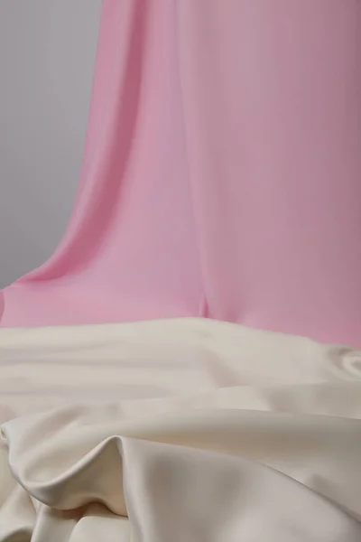 Selektiver Fokus aus rosa und weißen weichen und welligen Stoffen isoliert auf grau — Stockfoto