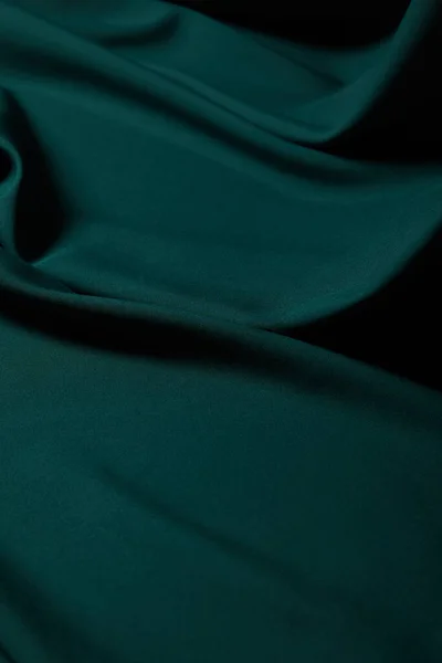 Вид изумрудной мягкой и волнистой шелковой ткани — стоковое фото