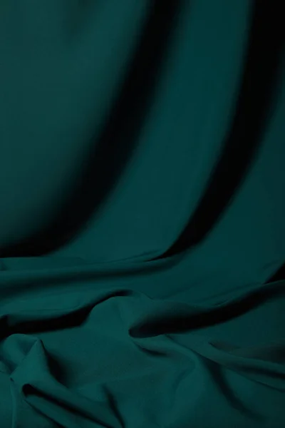 Vista da vicino del tessuto di seta smeraldo morbido e ondulato — Foto stock