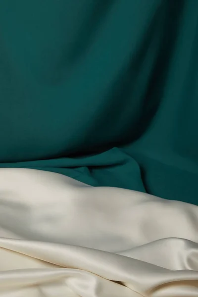 Vista de perto de esmeralda e tecido de seda macio e ondulado branco — Fotografia de Stock