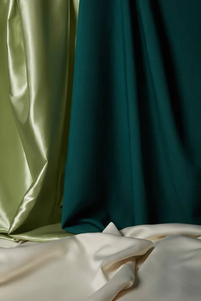 Close up view of emerald, light green and white soft and wavy silk fabric — Stock Photo