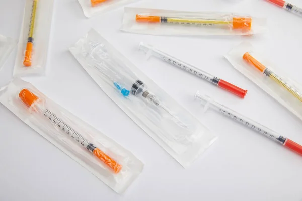 High angle view of syringes on white background — Stock Photo