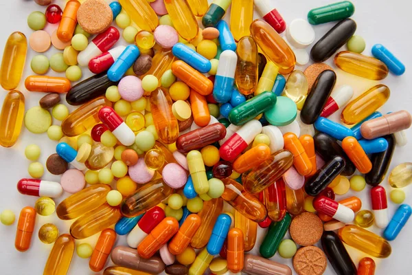 Top view of bright capsules and pills on white background — Stock Photo