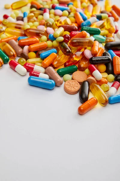 Concentration sélective de capsules et pilules lumineuses sur fond blanc — Photo de stock