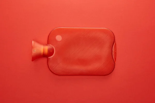 Vista superior de la botella de agua caliente aislada en rojo - foto de stock