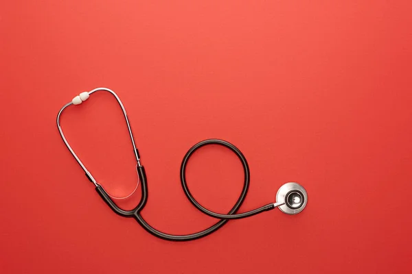 Top view of stethoscope on red background — Stock Photo
