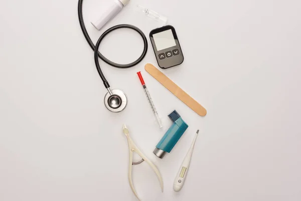 Vue du dessus de la seringue, de l'ampoule et des objets médicaux sur blanc — Photo de stock