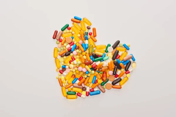 Visão superior do coração de pílulas coloridas isoladas em branco — Fotografia de Stock