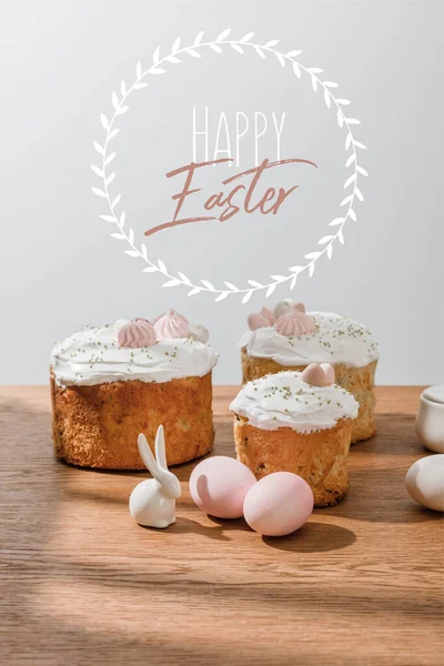 Decorative bunny, chicken eggs, sugar bowl with Easter cakes isolated on grey with happy Easter illustration — Stock Photo