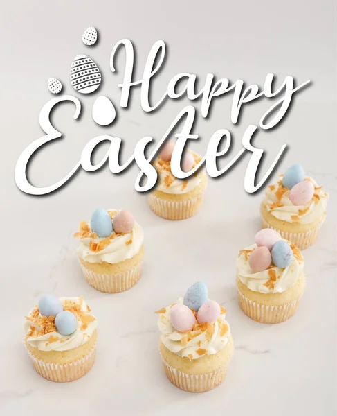 Deliciosos cupcakes de Pascua con huevos de codorniz pintados en la parte superior sobre fondo blanco con feliz ilustración de Pascua - foto de stock