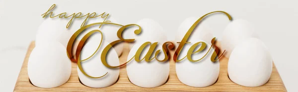 Wooden egg tray with chicken eggs on white background with happy Easter illustration — Stock Photo