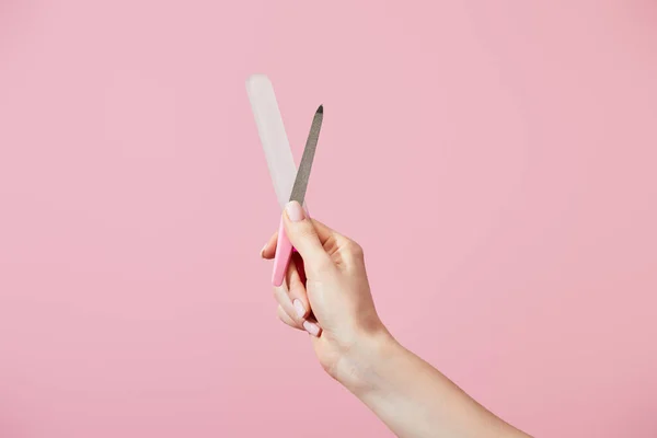 Vista ritagliata della mano femminile con lime per unghie isolate su rosa — Foto stock