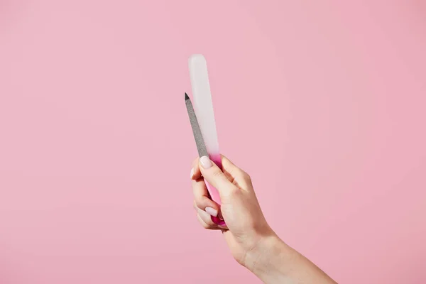 Partielle Ansicht der weiblichen Hand mit Nagelfeilen isoliert auf rosa — Stockfoto