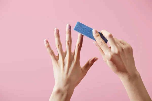 Partial view of woman doing manicure with nail buffer isolated on pink — Stock Photo