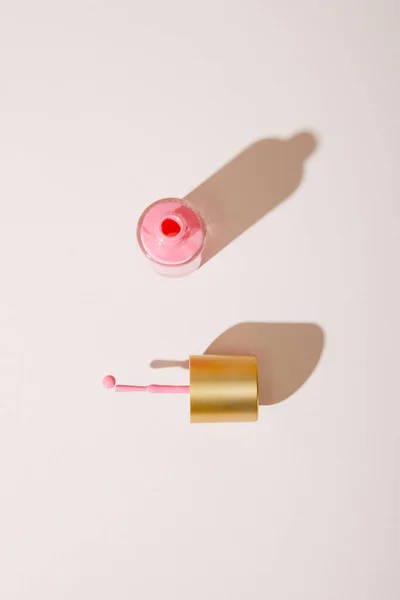 Top view of opened bottle of pink nail polish on white background — Stock Photo