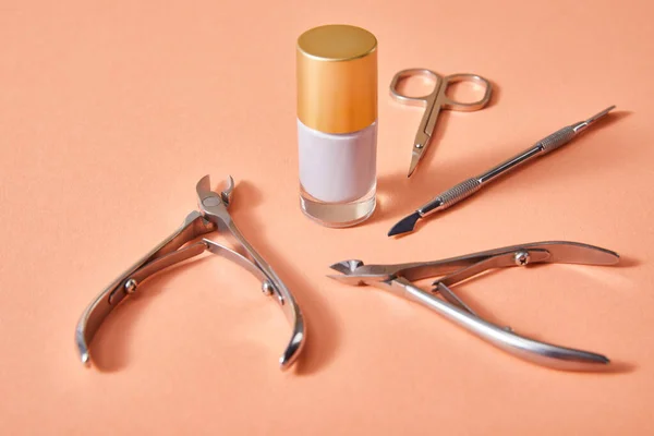 High angle view of bottle of white nail polish with manicure instruments on coral — Stock Photo