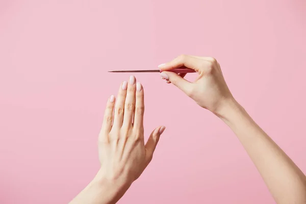 Vista cortada de mulher com arquivo de unhas isolado em rosa — Fotografia de Stock