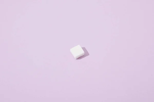 Lump sugar cube on violet background with copy space — Stock Photo