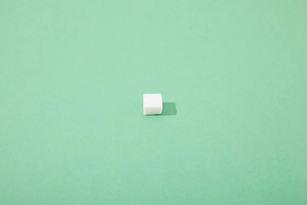 Lump sugar cube on green background with copy space — Stock Photo