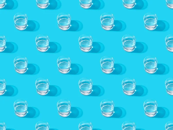 Glasses of water on blue, seamless background pattern — Stock Photo