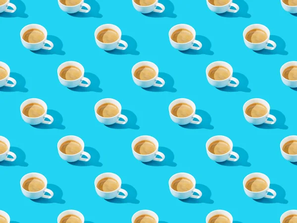 Чашки свіжої кави на синьому, безшовному фоновому візерунку — стокове фото