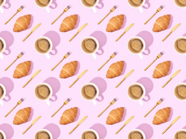 Top view of cutlery, croissants on plates and coffee on pink, seamless background pattern — Stock Photo