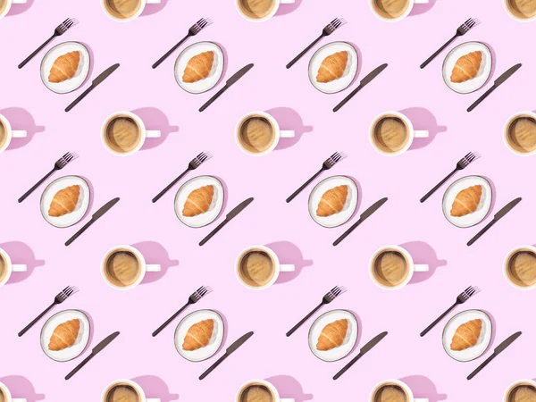 Top view of cutlery, croissants on plates and coffee on pink, seamless background pattern — Stock Photo