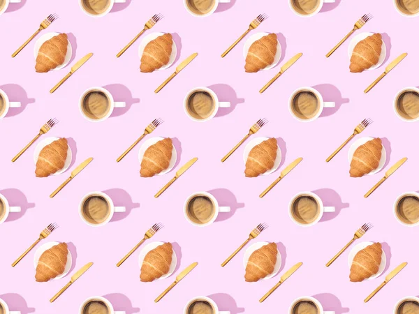 Top view of cutlery, croissants on plates and coffee on pink, seamless background pattern — Stock Photo