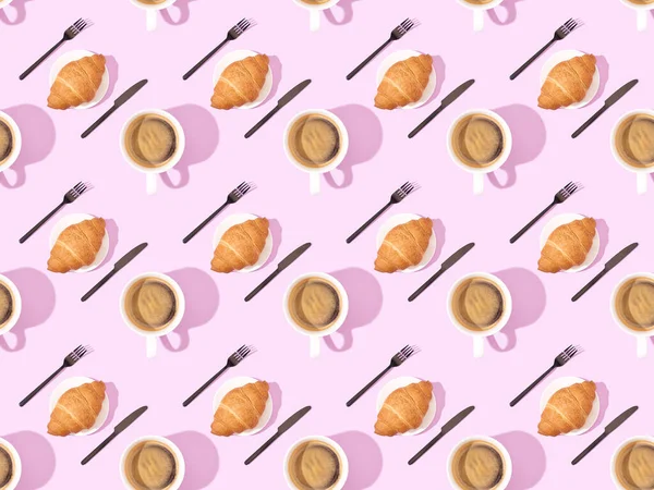 Top view of cutlery, croissants on plates and coffee on pink, seamless background pattern — Stock Photo