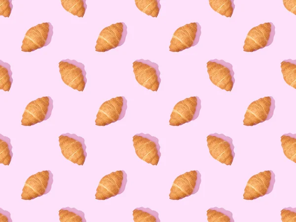 Top view of croissants on pink, seamless background pattern — Stock Photo