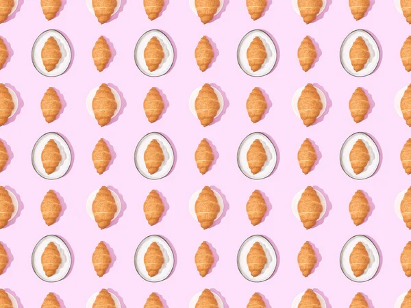 Top view of croissants on plates on pink, seamless background pattern — Stock Photo