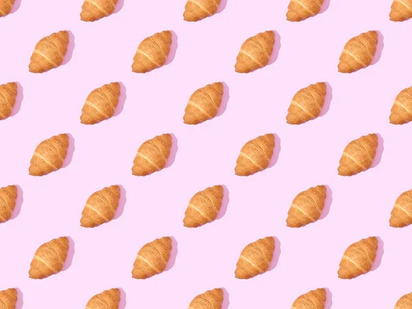 Top view of croissants on pink, seamless background pattern — Stock Photo