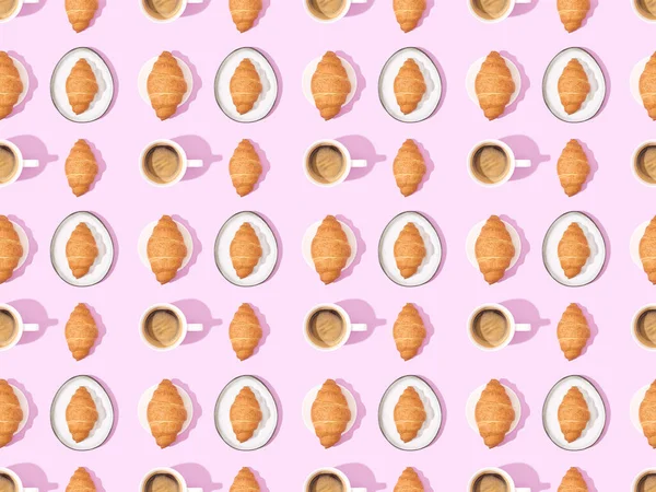 Draufsicht auf Croissants und Kaffee auf rosa, nahtlosem Hintergrundmuster — Stockfoto