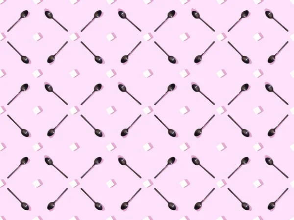 Top view of lump sugar with black spoons on violet, seamless background pattern — Stock Photo