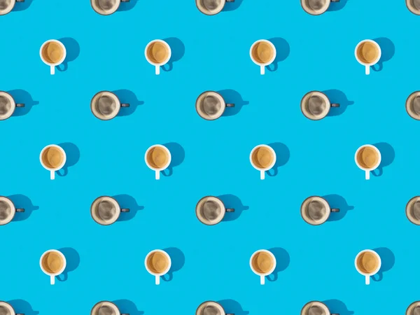 Ansicht von Tassen mit frischem Kaffee auf blauem, nahtlosem Hintergrundmuster — Stockfoto