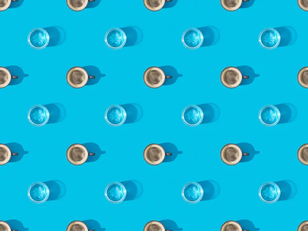 Vista dall'alto di tazze di caffè fresco e bicchieri d'acqua su blu, modello di sfondo senza soluzione di continuità — Foto stock
