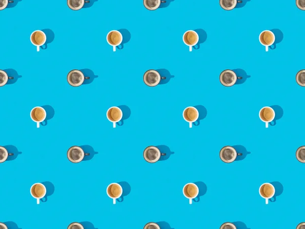 Vue de dessus des tasses de café frais sur bleu, motif de fond sans couture — Photo de stock