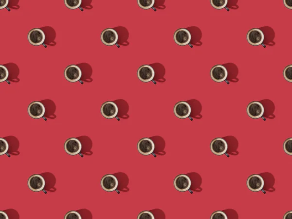 Top view of cups of fresh coffee on red, seamless background pattern — Stock Photo