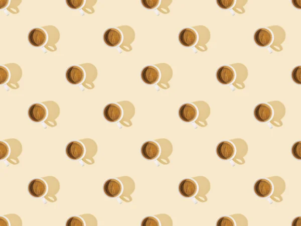 Top view of cups of fresh coffee on beige, seamless background pattern — Stock Photo