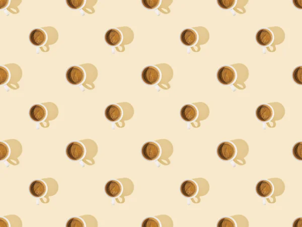 Vista superior de tazas de café fresco en color beige, patrón de fondo sin costuras - foto de stock