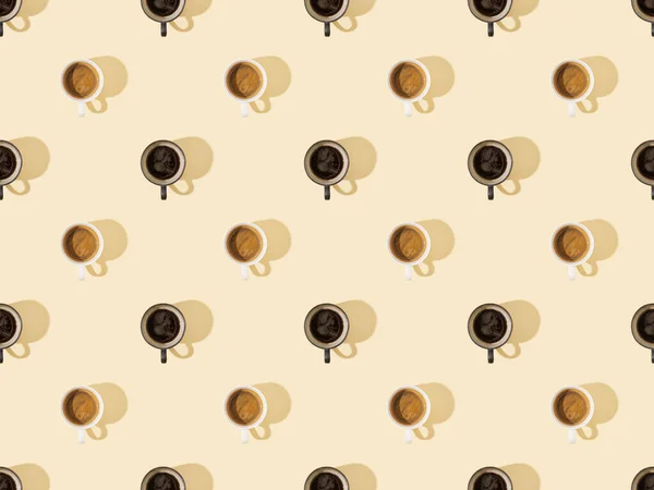 Vista superior de xícaras de café fresco em bege, padrão de fundo sem costura — Fotografia de Stock