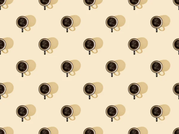 Vue de dessus des tasses de café frais sur beige, motif de fond sans couture — Photo de stock