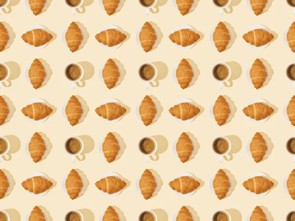 Top view of croissants and coffee on beige, seamless background pattern — Stock Photo