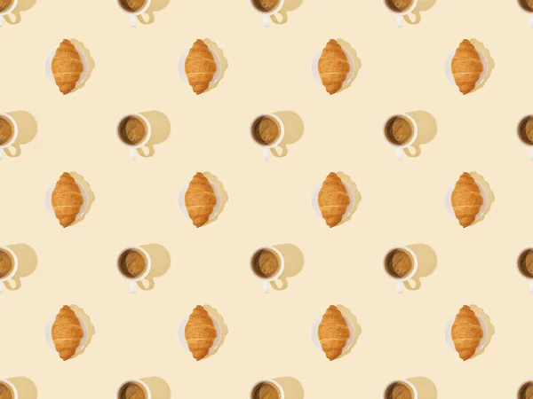 Vue de dessus des croissants et du café sur fond beige, motif sans couture — Photo de stock