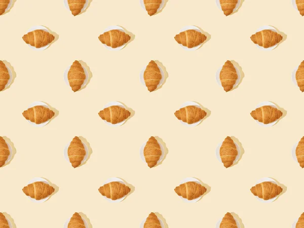 Top view of fresh croissants on beige, seamless background pattern — Stock Photo