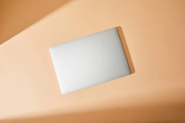 Top view of closed white laptop on beige background — Stock Photo