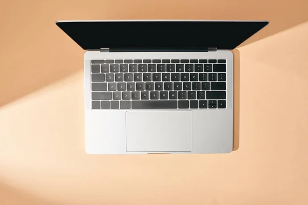 Vista superior do laptop aberto com tela em branco no fundo bege — Fotografia de Stock