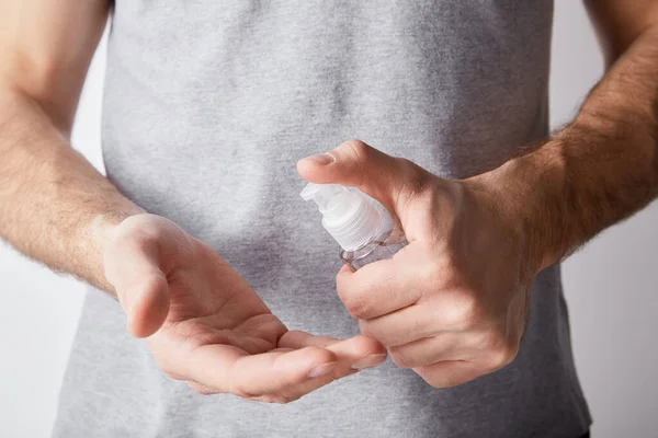 Vista recortada del hombre adulto usando desinfectante de manos en botella de dispensador - foto de stock